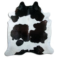 Black and white cowhide rug of about 220 × 190 cm, seen from above: the exact hide you receive