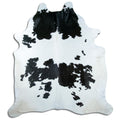 Black and white cowhide rug of about 240 × 210 cm, seen from above: the exact hide you receive