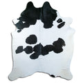 Black and white cowhide rug of about 230 × 180 cm, seen from above: the exact hide you receive