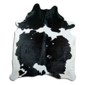 Black and white cowhide rug of about 230 × 200 cm, seen from above: the exact hide you receive