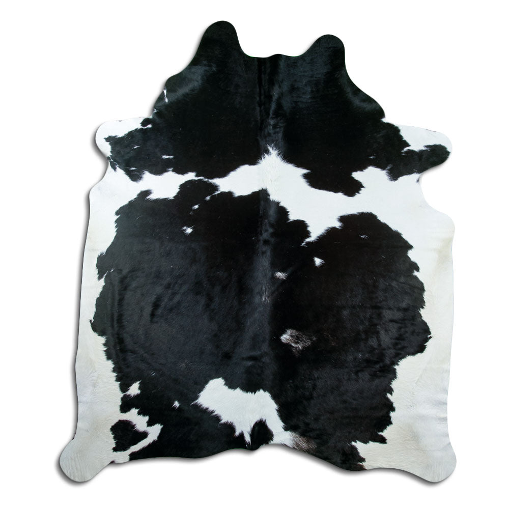 Black and white cowhide rug of about 230 × 200 cm, seen from above: the exact hide you receive