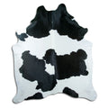 Black and white cowhide rug of about 230 × 190 cm, seen from above: the exact hide you receive