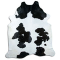 Black and white cowhide rug of about 250 × 220 cm, seen from above: the exact hide you receive
