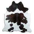 Black and white cowhide rug of about 200 × 190 cm, seen from above: the exact hide you receive