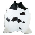 Black and white cowhide rug of about 210 × 190 cm, seen from above: the exact hide you receive