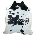 Black and white cowhide rug of about 230 × 200 cm, seen from above: the exact hide you receive