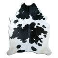 Black and white cowhide rug of about 230 × 200 cm, seen from above: the exact hide you receive