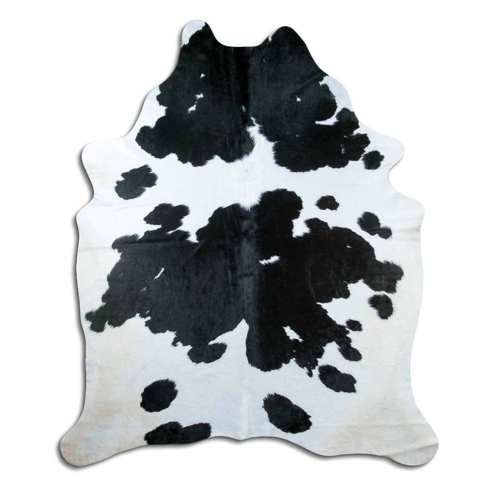 Black and white cowhide rug of about 230 × 200 cm, seen from above: the exact hide you receive