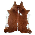Brown and white cowhide rug of about 220 × 200 cm, seen from above: the exact hide you receive
