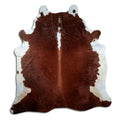 Brown and white cowhide rug of about 220 × 200 cm, seen from above: the exact hide you receive