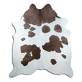 Brown and white cowhide rug of about 210 × 180 cm, seen from above: the exact hide you receive