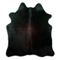 Black cowhide rug of about 170 × 150 cm, seen from above: the exact hide you receive