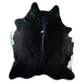 Black cowhide rug of about 220 × 190 cm, seen from above: the exact hide you receive