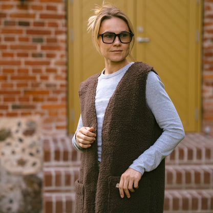 A woman in the brown Sea merino vest, close up