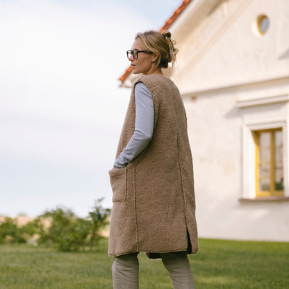 The beige Sea merino vest from the side, outdoors