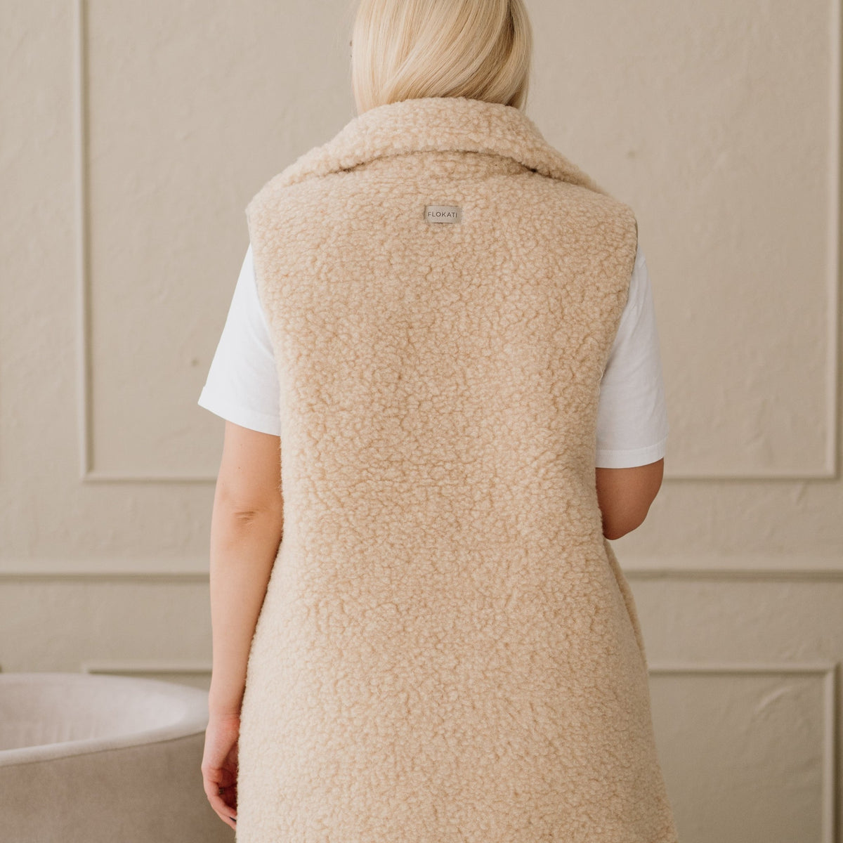 The beige Wave merino vest from the back