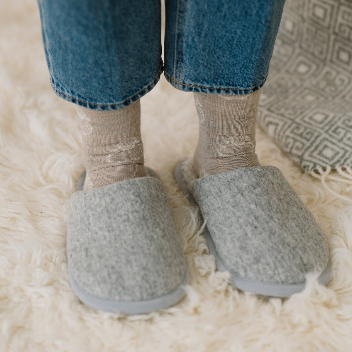 Marble merino slippers worn on a sheepskin rug