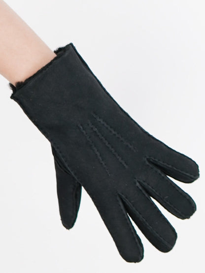 Black sheepskin glove worn on the hand