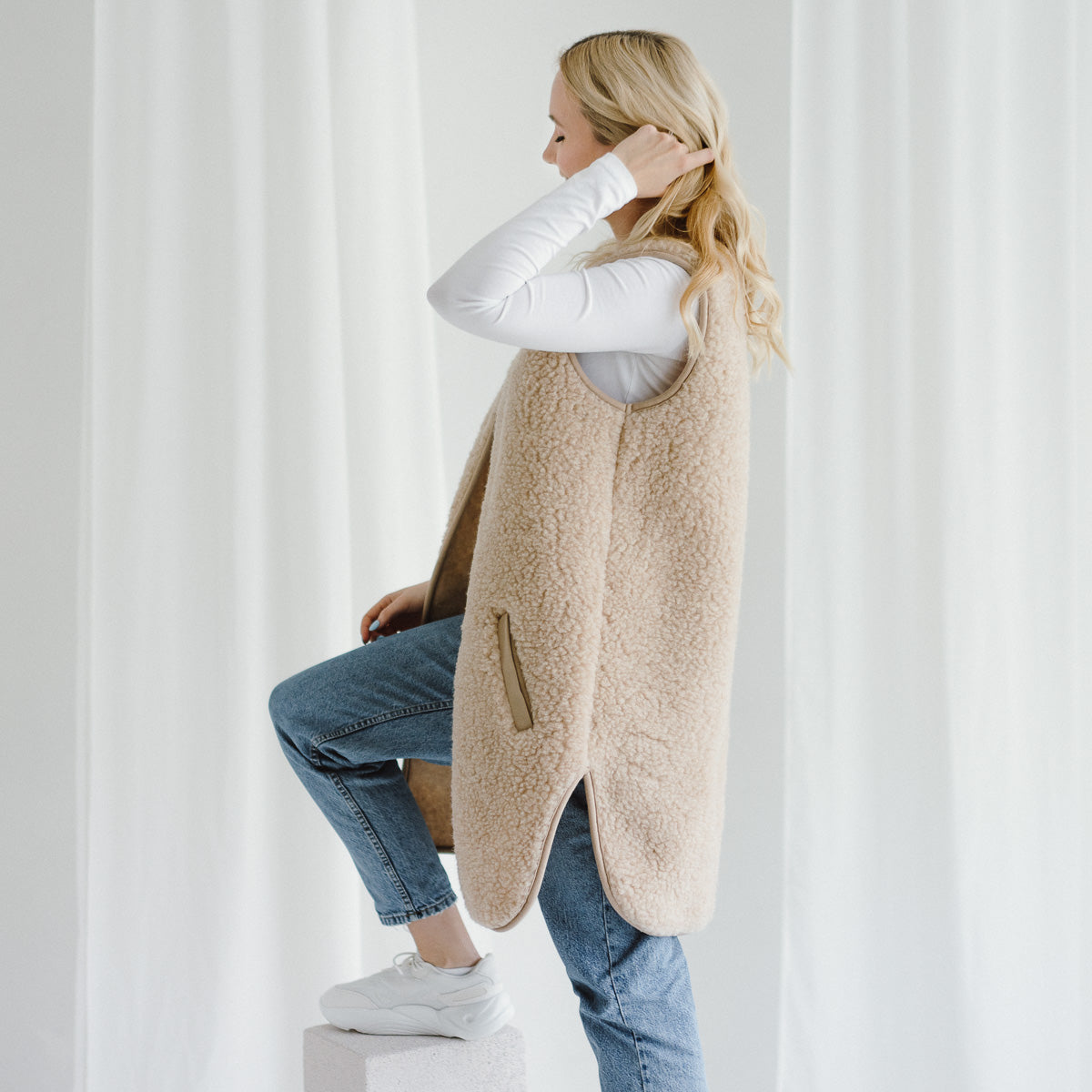 The beige Pearl merino vest from the side
