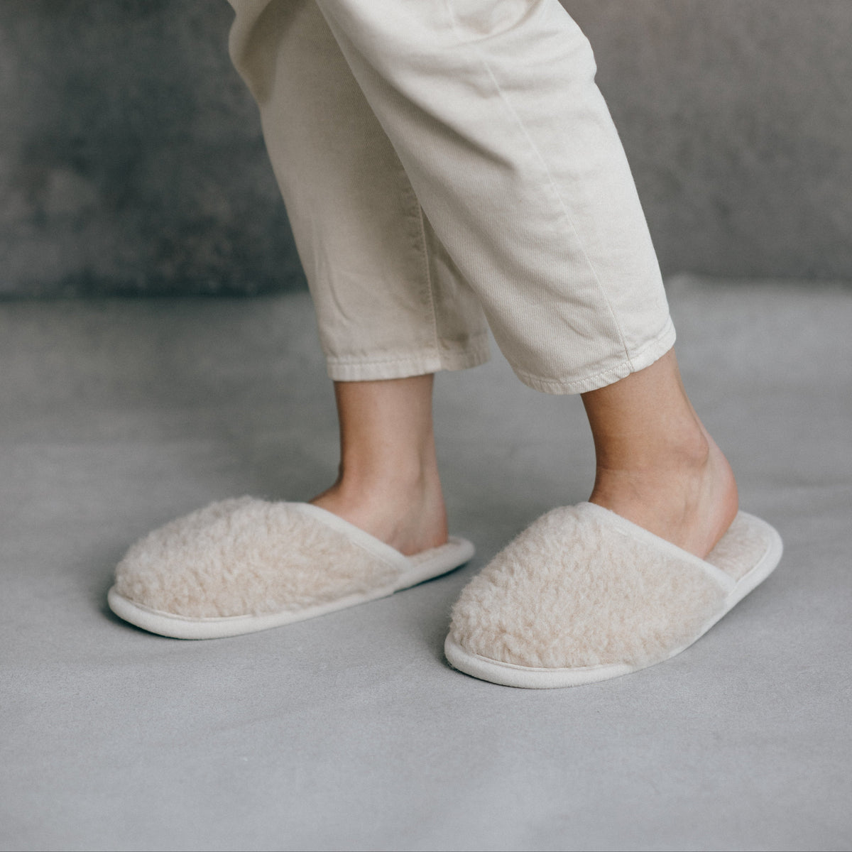 Beige merino slippers worn with jeans