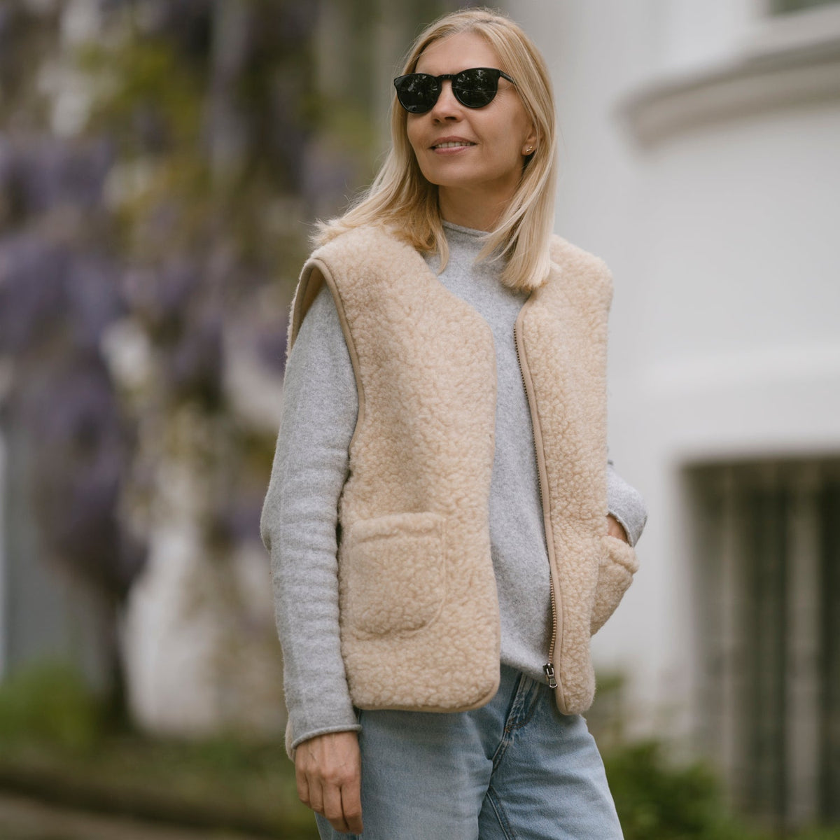 The beige Island merino vest worn outdoors