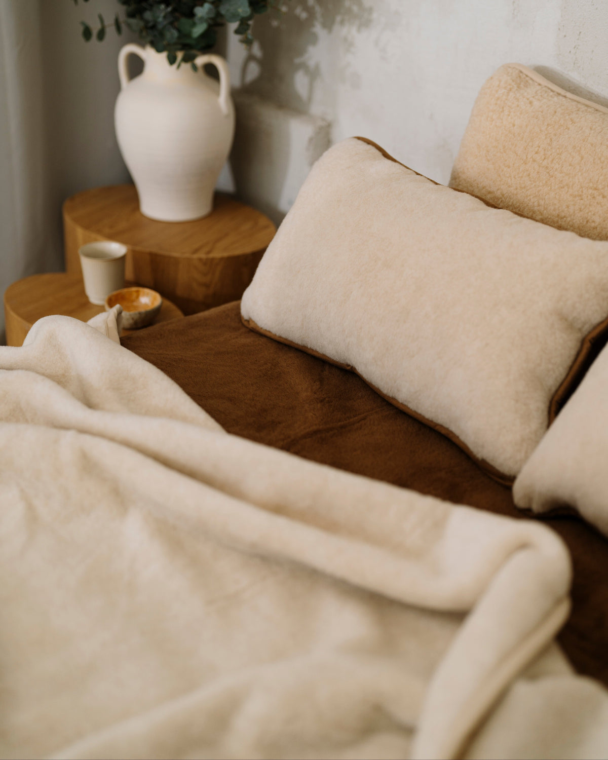 Caramel wool blanket turned back on a bed