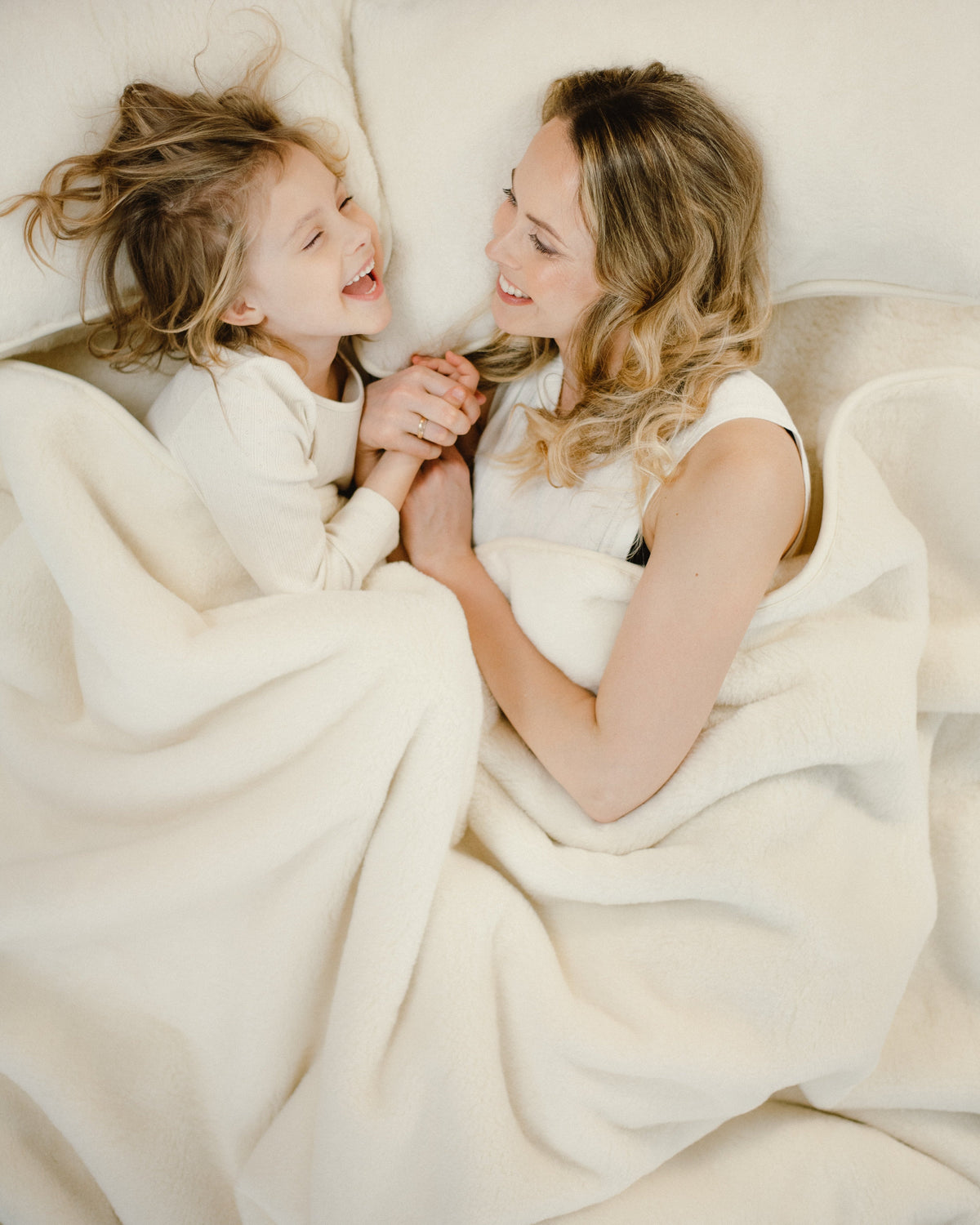 An adult and a child cuddled up under the Cashmere wool blanket