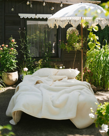 Cashmere wool blanket on a bed set up in a garden