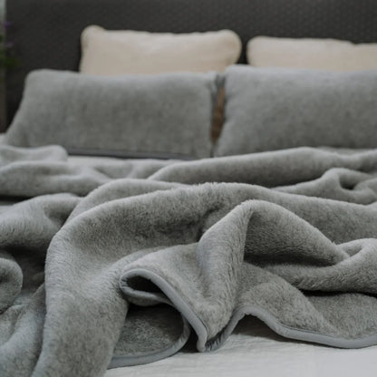 Meringue 2-ply merino blanket on a bed