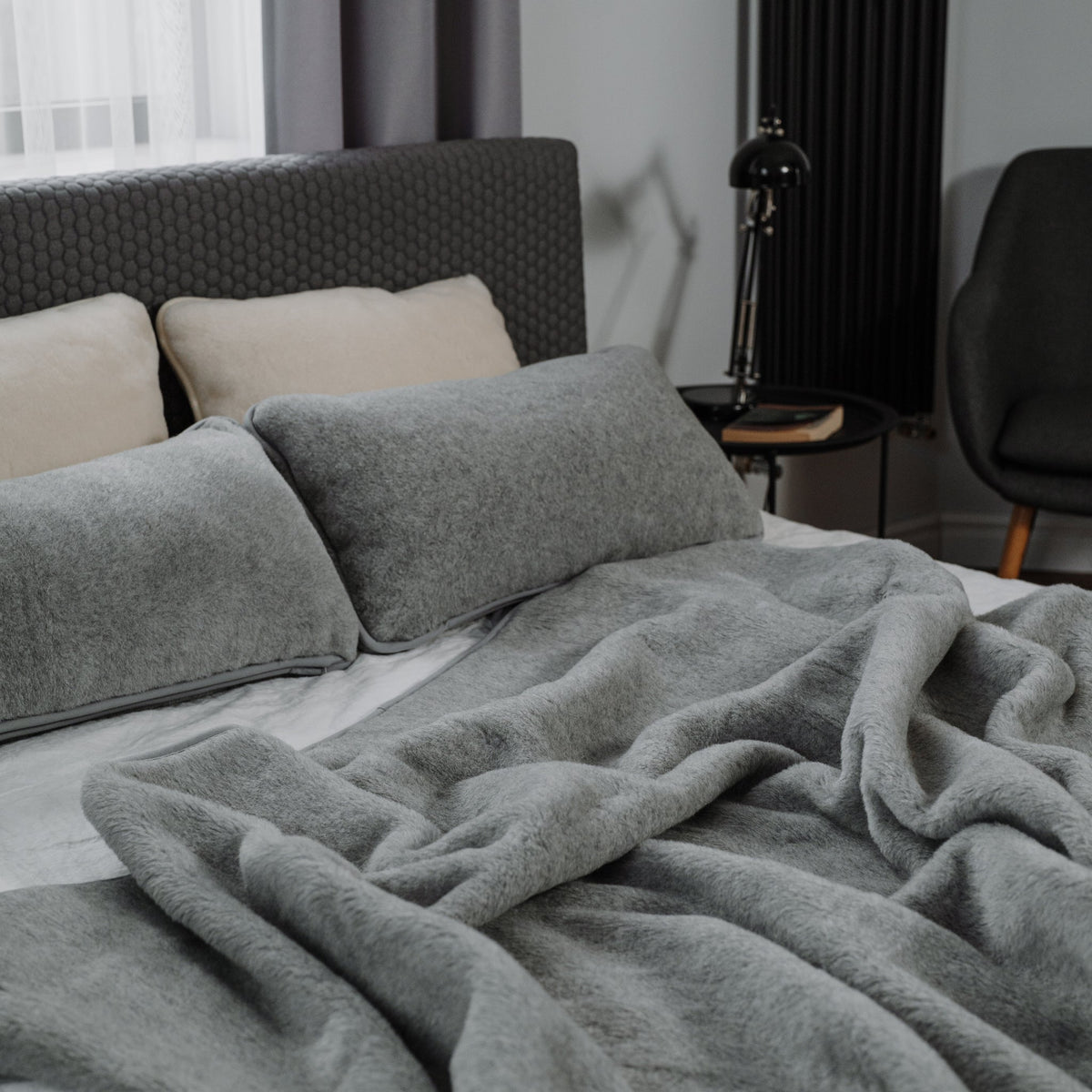 Meringue 2-ply merino blanket on a bed with wool pillows
