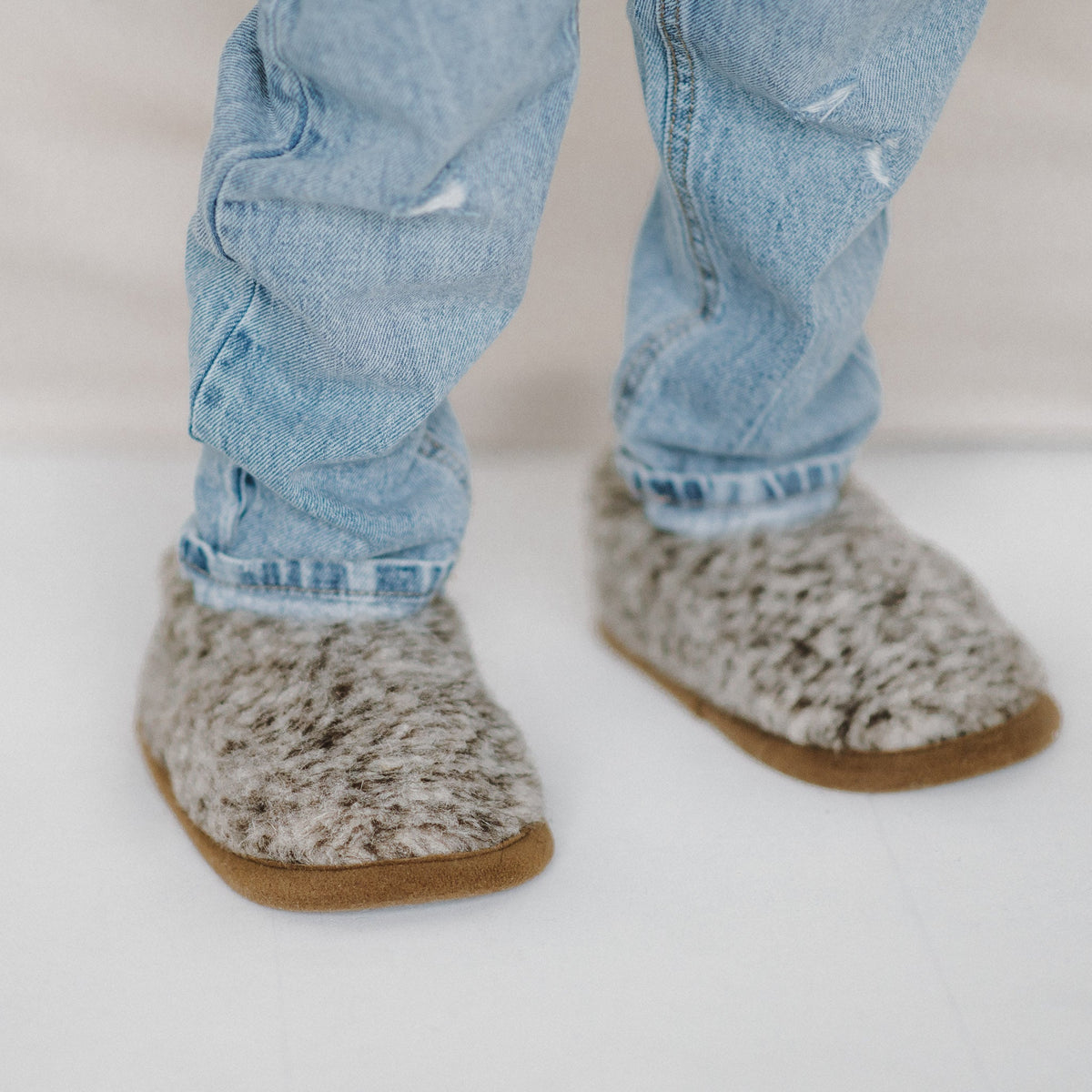A child wearing Tiger merino slippers with jeans