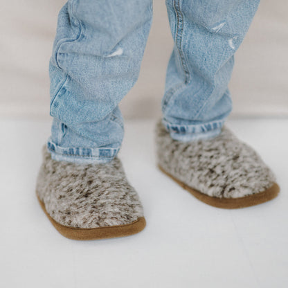 A child wearing Tiger merino slippers with jeans