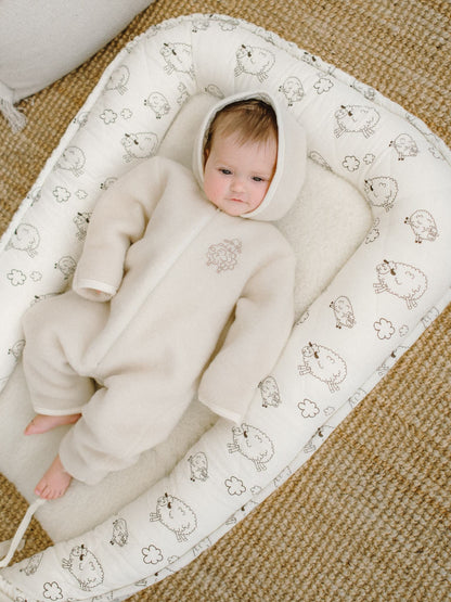 A baby in the ecru merino romper Sheep
