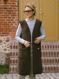 A woman wearing the long Sea merino vest in brown