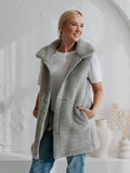 A woman wearing the Wave merino vest in grey