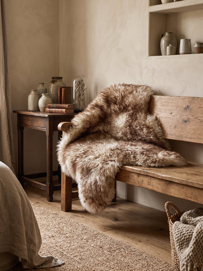 Mouflon sheepskin over a wooden bench beside a sideboard