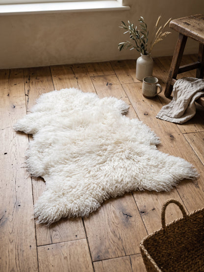 White curly sheepskin on a wooden floor